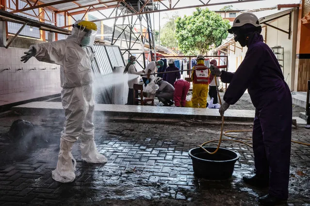 A disinfection worker wearing protective gear sprays disinfectant to a medical worker after they perform swab tests for the coronavirus disease (COVID-19) during mass test at Islamic boarding school of Sunan Pandanaran on July 29, 2020 in Yogyakarta, Indonesia. Indonesia is struggling to contain hundreds of new daily cases of coronavirus amid easing of rules to allow economic activity to resume, has reported more than 100,000 coronavirus cases and with at least more 4,900 recorded fatalities. (Photo by Ulet Ifansasti/Getty Images)