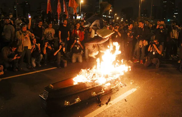 An anti-government demonstrator jumps over a coffin that represents a symbolic funeral of Brazil's President Michel Temer during a protest in Sao Paulo, Brazil, September 4, 2016. (Photo by Fernando Donasci/Reuters)
