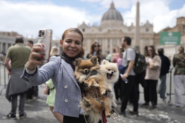 A woman takes a selfie with her two dogs next to St. Peter's Square at the Vatican, Thursday April 24, 2025. (Photo by Markus Schreiber/AP Photo)