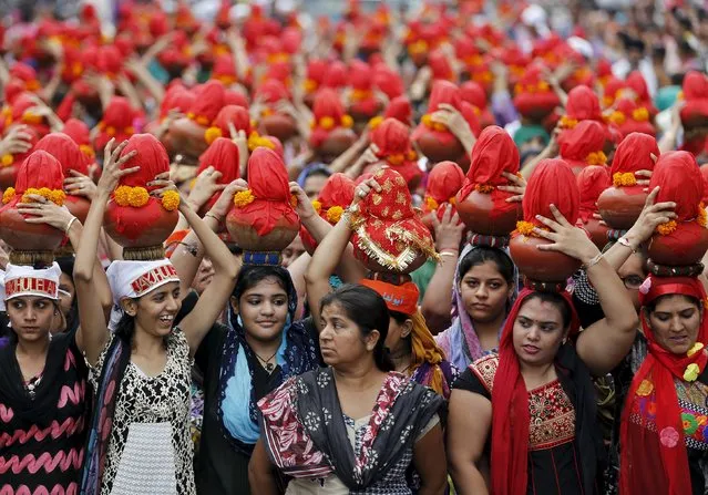 Devotees carry earthen water pots as they take part in a Jhulelal Chaliha procession in Ahmedabad, India, September 19, 2015. Jhulelal Chaliha, a 40-day-long fasting festival of the Sindhi community, ended on Saturday with a colourful procession of earthen pots carried by hundreds of male and female devotees on their heads for what they say to be the betterment of their family and society. (Photo by Amit Dave/Reuters)