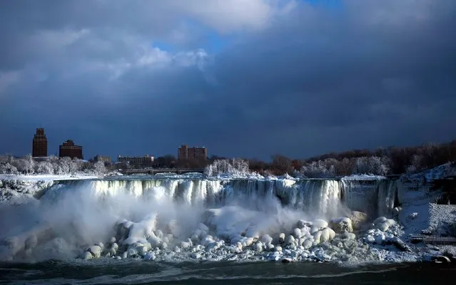 Water flows over the American Falls as ice forms in this view from the Canadian side in Niagara Falls, Ont., Tuesday, Januaary 2, 2018. Almost every year frigid temperatures transform the falls into an icy winter wonderland when the mist is blown back, freezing on the landscape. (Photo by Aaron Lynett/The Canadian Press via AP Photo)