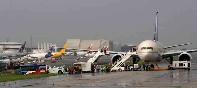 Passengers disembark from a Saudi Arabia Airlines plane parked at the tarmac of Ninoy Aquino International airport in Pasay city, Metro Manila, Philippines September 20, 2016. A Saudia plane was placed in isolation at the Ninoy Aquino International Airport, according to a Manila International Airport Authority (MIAA) officials. Manila Control Tower received an advisory that the Saudia flight SVA 872 from Jeddah is under threat before it lands, a statement from the MIAA said. The airline later confirmed it had been a “false alarm for hijacking”. (Photo by Erik De Castro/Reuters)