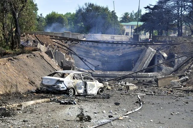 A burned out vehicle marks the spot where a gas tanker exploded under a bridge in Boksburg, east of Johannesburg, Saturday, December 24, 2022. A truck carrying liquified petroleum gas has exploded in the South African town of Boksburg, killing at least 8 people and injuring more than 50 others on Saturday. (Photo by Hein Kaiser/AP Photo)