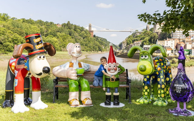 Freddie Hine-Haycock, 6, on June 11, 2025 poses with sculptures made for the Gromit Unleashed 3 trail in Bristol, UK — home of the characters’ creator, Aardman Animations. (Photo by Tom Wren/South West News Service)