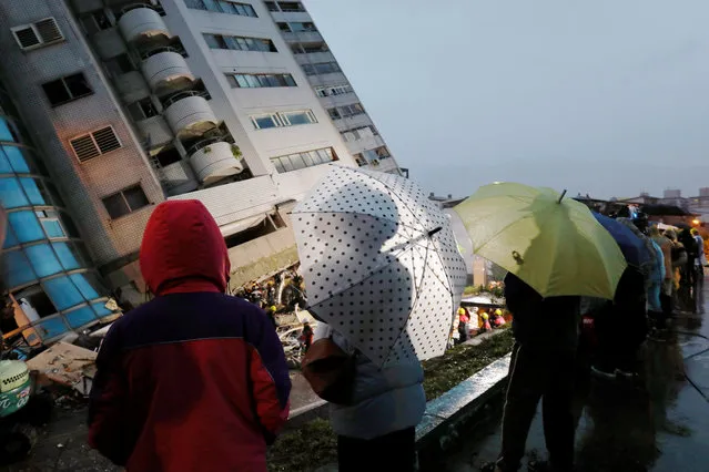 People look at a damaged residential building in Hualien, Taiwan February 7, 2018. (Photo by Tyrone Siu/Reuters)