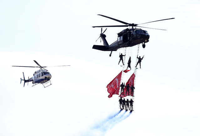 Police unit hangs from a helicopter with Turkish flags as they perform during the 5th Sivrihisar Airshow in Sivrihisar district of Eskisehir, Turkey on September 13, 2020. (Photo by Ali Atmaca/Anadolu Agency via Getty Images)