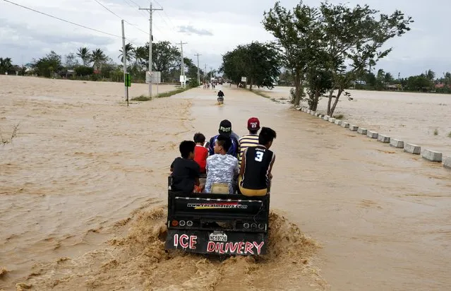 Residents are transported on a "ice delivery" vehicle along a flooded highway in Sta Rosa, Nueva Ecija in northern Philippines October 19, 2015, after it was hit by Typhoon Koppu. (Photo by Erik De Castro/Reuters)
