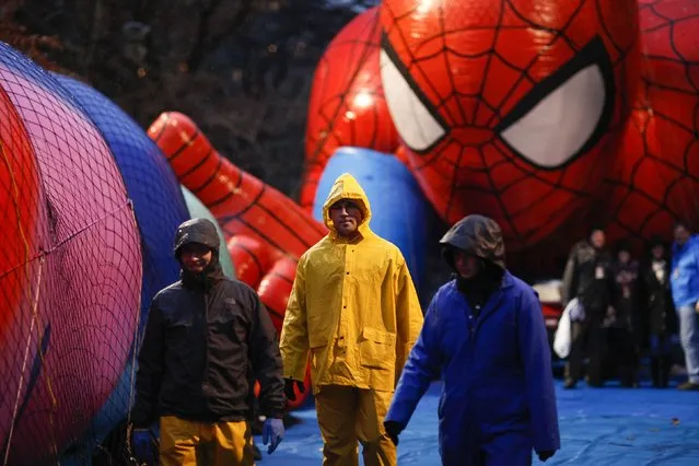 Members of the Macy's Thanksgiving Day Parade balloon inflation team check balloons during preparations for the 88th annual Macy's Thanksgiving Day Parade in New York, November 26, 2014. (Photo by Eduardo Munoz/Reuters)