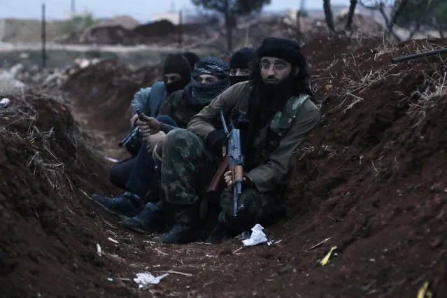 Members of al Qaeda's Nusra Front carry their weapons as they sit  in a trench near al-Zahra village, north of Aleppo city, November 25, 2014. Members of al Qaeda's Nusra Front and other Sunni Islamists seized an area south of the Shi'ite Muslim village in north Syria on Sunday after clashes with pro-government fighters, opposition activists said. (Photo by Hosam Katan /Reuters)