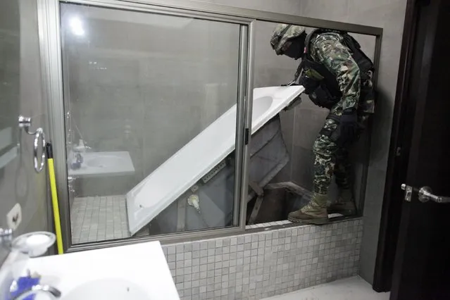 A Mexican marine lifts a bathtub that leads to a tunnel and exits in the city's drainage system at one of the houses of Joaquin “Chapo” Guzman in Culiacan, in this February 27, 2014 file photo. (Photo by Daniel Becerril/Reuters)