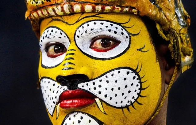 A traditional tiger dancer waits to perform during a Save Our Tigers awareness campaign in Kolkata, India, on March 21, 2013. India's latest tiger census counted at least 1,706 tigers in forests across the country. As many as 100,000 tigers are thought to have roamed India a 100 years ago. (Photo by Bikas Das/Associated Press)