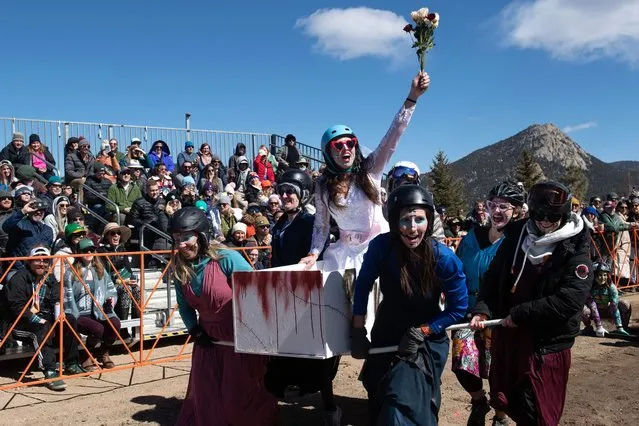 Shannon Carey (C) of Denver, Colorado, celebrates as her Bride or Die teammates carry her in a homemade coffin during the coffin races at the Frozen Dead Guy Days festival at the Estes Park Events Complex in Estes Park, Colorado, on March 18, 2023. The festival, which originally took place in Nederland, Colorado, began after the frozen body of a deceased Norwegian man, Bredo Morstøl, was found in a shed there. The body of Morstøl, who died in 1989, was cryogenically frozen by his family members and shipped to the United States. Legends about Morstøl became popular among Nederland, Colorado, residents, and they created this festival to honor him. (Photo by Jason Connolly/AFP Photo)