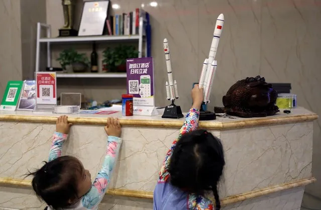Children play with models of rockets at the reception desk of a hotel in Longlou town, Wenchang, Hainan province, China, November 22, 2020. (Photo by Tingshu Wang/Reuters)