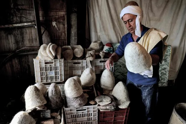 Hatmaker Youssef Akiki inspects some of his traditional “Labbadeh” hats at his workshop in the mountain village of Hrajel in Keserwan-Jbeil province on January 27, 2023. High in Lebanon's rugged mountains, Akiki is among the last practising the thousand-year-old skill of making warm wool caps once worn by mountaineers during the snows of winter. (Photo by Joseph Eid/AFP Photo)