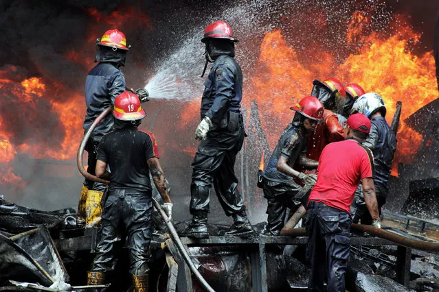 Fire fighters try to extinguish fire at a rubber warehouse in West Sumatra, Indonesia, on April 23, 2018. No casualties were reported so far. (Photo by Andri Mardiansyah/Pacific Press/Barcroft Media)