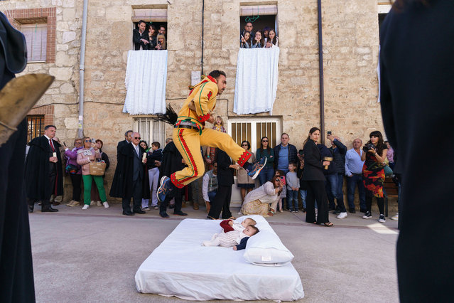The “Colacho”, a character that represents the devil, jumps over babies lying on a mattress in the street during “El Salto del Colacho” (The Devil's Jump) baby jumping festival, in the village of Castrillo de Murcia, near Burgos, on June 2, 2024. “El Colacho” is a traditional Spanish ritual dating back to 1620 during which men representing the Devil jump over babies born in the last twelve months of the year and takes place annually to celebrate the Catholic feast of Corpus Christi. (Photo by Cesar Manso/AFP Photo)