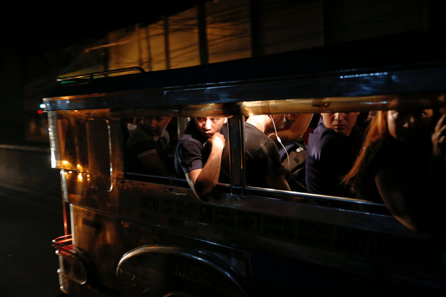 Passengers look from inside a passing jeepney at the site where a man was killed in a shootout with police in Manila, Philippines early October 21, 2016. (Photo by Damir Sagolj/Reuters)