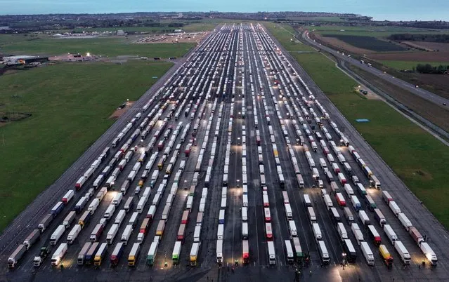 An aerial view shows lines of freight lorries and heavy goods vehicles parked on the tarmac at Manston Airport near Ramsgate, south east England on December 22, 2020, as the Brexit contingency plan “Operation Fennel” was activated early to cope with lorries waiting to depart the UK, after France closed its borders to accompanied freight arriving from the UK due to the rapid spread of a new coronavirus strain. The British government said Tuesday it was considering tests for truckers as part of talks with French authorities to allow the resumption of freight traffic suspended due to a new more infectious coronavirus strain. (Photo by William Edwards/AFP Photo)