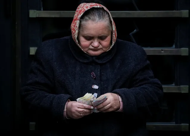 A woman counts money in central Lviv, Ukraine, October 20, 2016. Picture taken October 20, 2016. (Photo by Gleb Garanich/Reuters)