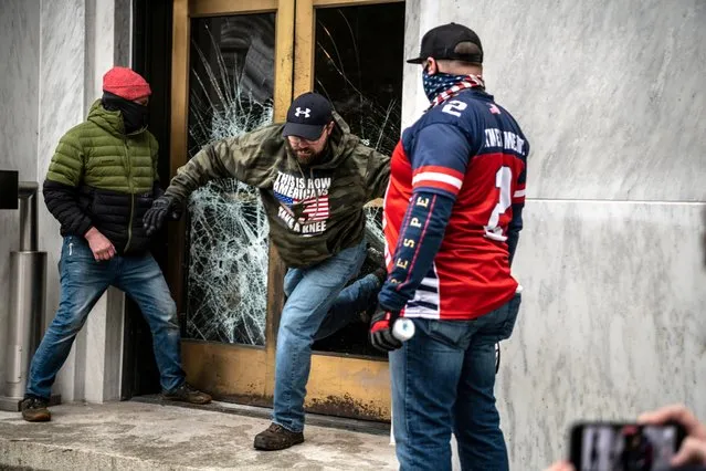 Far-right protesters break the door to the Capitol building during a protest against restrictions to prevent the spread of coronavirus disease (COVID-19) in Salem, Oregon, U.S., December 21, 2020. (Photo by Mathieu Lewis-Rolland/Reuters)