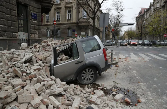 A car is crushed by falling debris after an earthquake in Zagreb, Croatia, Sunday, March 22, 2020. A strong earthquake shook Croatia and its capital on Sunday, causing widespread damage and panic. (Photo by Darko Bandic/AP Photo)