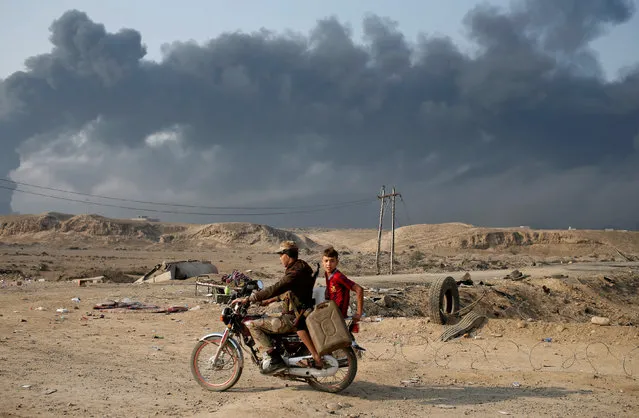 Armed members of Shi'ite militia Hashid Shaabi ride a motorbike near Qayyara, south of Mosul, Iraq October 27, 2016. (Photo by Goran Tomasevic/Reuters)