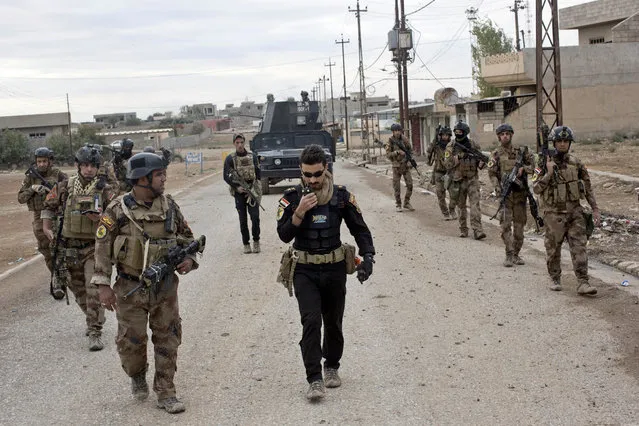 Iraqi special forces soldiers patrol a street in Gogjali, an eastern district of Mosul, Iraq, Wednesday, November 2, 2016. Iraqi special forces paused their advance in the eastern district of Mosul on Wednesday to clear a neighborhood of any remaining Islamic State militants, killing at least eight while carrying out house-to-house searches. (Photo by Marko Drobnjakovic/AP Photo)