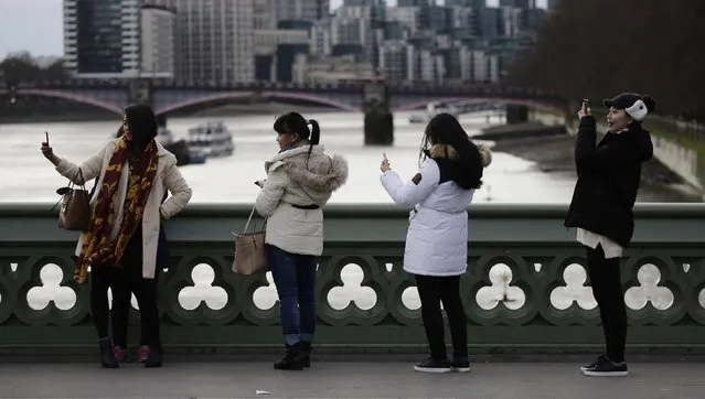People take a photos with their phones whilst standing on Westminster Bridge in London January 10, 2015. (Photo by Kevin Coombs/Reuters)