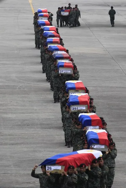Members of the Philippine National Police's (PNP) Special Action Force (SAF) unit carry metal caskets containing the bodies of slain SAF police who were killed in Sunday's clash with Muslim rebels, upon arriving at Villamor Air Base in Pasay city, metro Manila January 29, 2015. (Photo by Romeo Ranoco/Reuters)