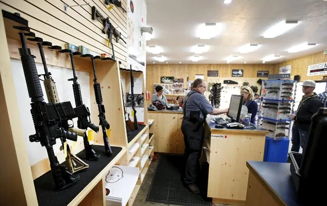 David Warren rings up customers sales next to assault rifles on display at the Ringmasters of Utah gun range and store, in Springville, Utah on December 18, 2015. (Photo by George Frey/Reuters)