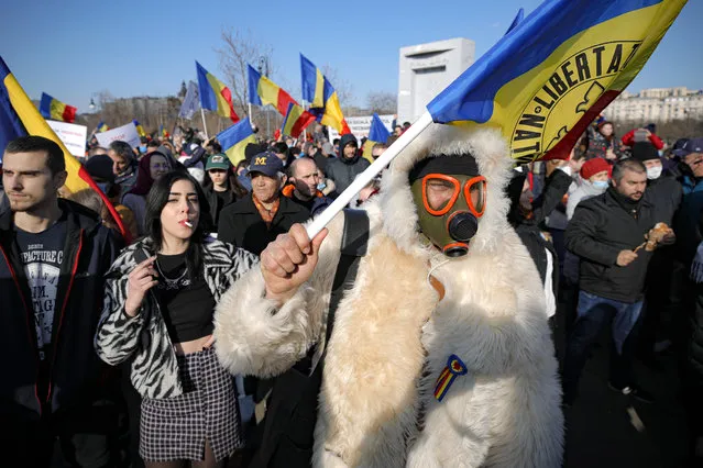 Anti-vaccination protesters rally outside the parliament building in Bucharest, Romania, Sunday, March 7, 2021. (Photo by Vadim Ghirda/AP Photo)