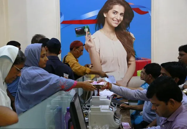 Indians exchange discontinued currency notes in a bank in Mumbai, India, Wednesday, November 16, 2016. India announced a week ago that it was withdrawing 500 and 1,000 rupee notes as legal tender to fight corruption and tax evasion. However, people are allowed a onetime swap of 4,000 rupees ($59) at any bank in exchange for smaller notes to meet immediate needs. (Photo by Rajanish Kakade/AP Photo)