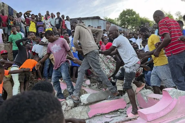 People carry an injured person away from a home that collapsed due to an earthquake in Jeremie, Haiti, Tuesday, June 6, 2023. (Photo by Ralph Simon/AP Photo)
