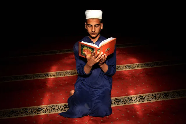 A Pakistani Muslim boy reads verses from the holy Koran at a Mosque during the fasting month of Ramadan, amid the coronavirus pandemic in Peshawar, Pakistan, 15 April 2021. Muslims around the world celebrate the holy month of Ramadan by praying during the night time and abstaining from eating, drinking, and sexual acts during the period between sunrise and sunset. Ramadan is the ninth month in the Islamic calendar and it is believed that the revelation of the first verse in Koran was during its last 10 nights. (Photo by Bilawal Arbab/EPA/EFE)