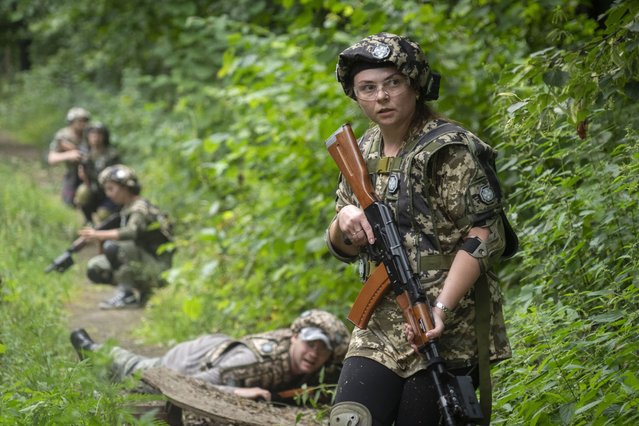 Volunteers practice during military training for civilians close to Kyiv, Ukraine, Friday, August 11, 2023. (Photo by Efrem Lukatsky/AP Photo)