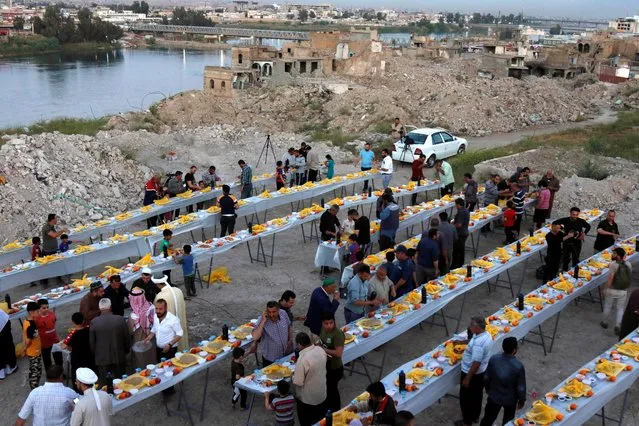 People gather to have their Iftar (breaking fast) meals during Ramadan, in Mosul, Iraq, April 15, 2021. (Photo by Khalid Al-Mousily/Reuters)