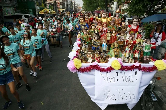Devotees dance beside different Sto. Nino (infant Jesus) replicas during a procession in Manila January 16, 2016, a day before the annual of the feast day of Sto. Nino on Sunday. (Photo by Romeo Ranoco/Reuters)