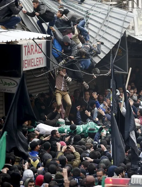 Palestinians fall down from a shop roof during the funeral of seven Hamas gunmen who were killed when a tunnel collapsed close to the Gaza Strip's eastern border with Israel in Gaza City, January 29, 2016. (Photo by Suhaib Salem/Reuters)