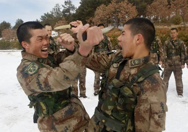 Soldiers from China's People's Liberation Army thrust daggers at each other during a training session in the city of Heihe in northeastern China's Heilongjiang province Wednesday, March 18, 2015. The Chinese government announced during this month's National People's Congress that it would increase defense spending by 10.1 percent, citing a need to modernize equipment and improve conditions. (Photo by AP Photo)