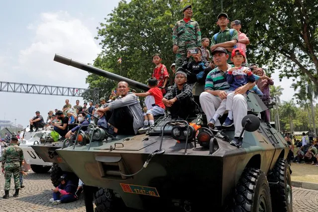 People sit on a military vehicle during the 78th Indonesian Military Anniversary celebrations at the National Monument (Monas) complex in Jakarta, Indonesia on October 5, 2023. (Photo by Willy Kurniawan/Reuters)