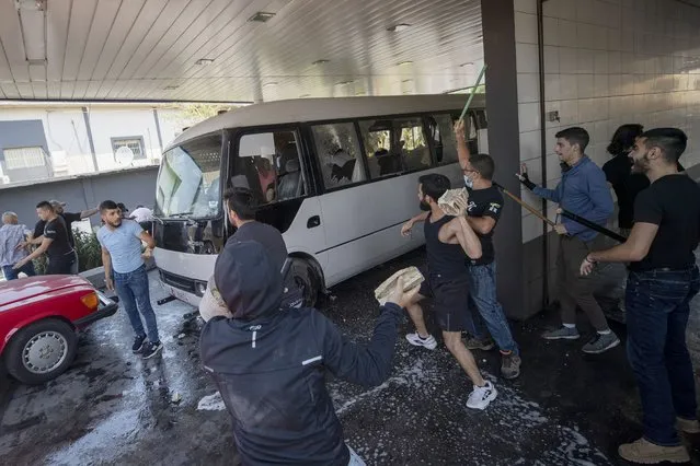 Members of the Christian rightwing Lebanese Forces group attack a bus carrying Syrian voters heading their embassy to vote in the Syrian presidential elections in the town of Zouk Mosbeh, north of Beirut, Lebanon, Thursday, May 20, 2021. (Photo by Hassan Ammar/AP Photo)