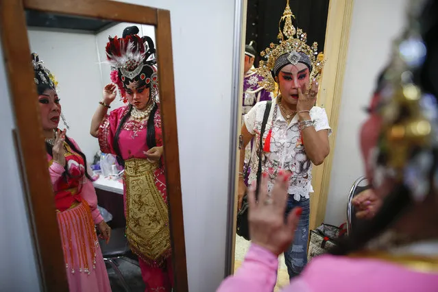 Members of a Chinese opera troupe apply make-up before a performance at a shopping mall ahead of the Chinese Lunar New Year celebrations in Bangkok, Thailand, February 4, 2016. (Photo by Athit Perawongmetha/Reuters)