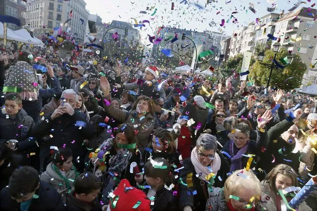 Several thousand people eat grapes at midday during a New Year's Eve party at City Hall square in the village of Vilagarcia, in Galicia, northwestern Spain, 31 December 2016. As every New Year's Eve the 12 strokes of the clock will announce the arrival of a new year at midnight. According to tradition, all people in the country will eat one grape with each stroke to be lucky in the upcoming year. (Photo by Lavandeira Jr./EPA)