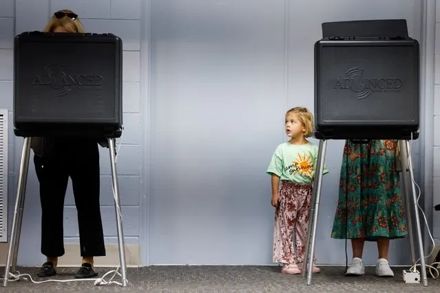 Libby, 4, waits while Catherine Bayliss fills out her ballot at a polling station in Richmond on Tuesday, November 7, 2023. (Julia Nikhinson/For The Washington Post)