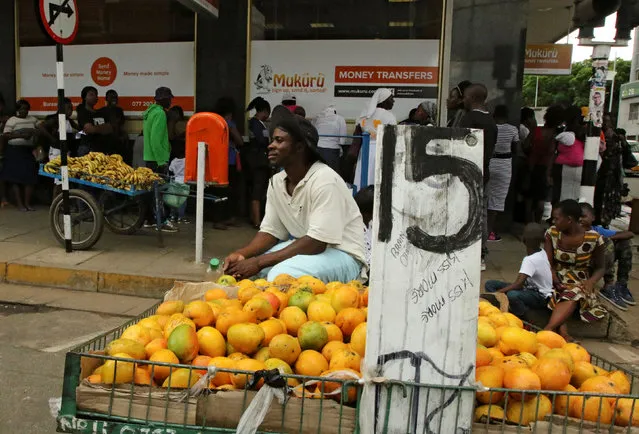 A fruit vendor waits to sell his goods outside a bank in central Harare, Zimbabwe December 19, 2016. (Photo by Philimon Bulawayo/Reuters)