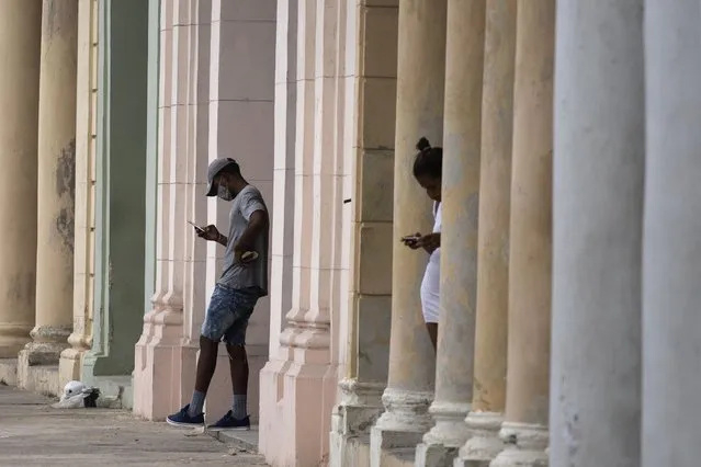 People use their cell phones where a pre-paid public wifi connection is working near the Malecon seawall in Havana, Cuba, Tuesday, July 14, 2021. The government responded to Sunday’s antigovernment protests by shutting down internet and mobile data services by the state-run phone monopoly, effectively cutting off social media. (Photo by Eliana Aponte/AP Photo)