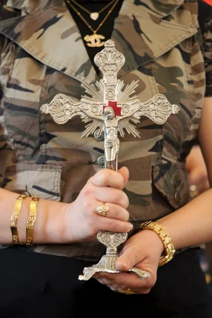 An Iraqi Christian woman holds a cross during an Easter mass at the Virgin Mary church in Basra, southeast of Baghdad, April 5, 2015. (Photo by Essam Al-Sudani/Reuters)