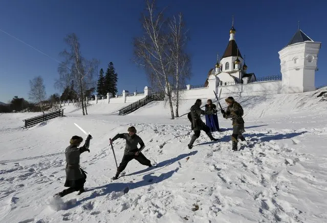 Members of the “Grifon” (Griffin) amateur club of artistic fencing, dressed as medieval East European soldiers and a woman, participate in a performance entitled “Duel for the lady's heart” to mark Valentine's Day near an Orthodox monastery on the bank of the Yenisei River on the surburbs of Krasnoyarsk, Russia, February 14, 2016. (Photo by Ilya Naymushin/Reuters)