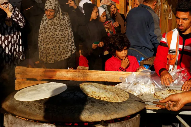 Palestinians wait to buy bread in Rafah, in the southern Gaza Strip on November 21, 2023. (Photo by Ibraheem Abu Mustafa/Reuters)