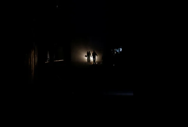 Palestinians walk on a road during a power cut in Beit Lahiya in the northern Gaza Strip January 11, 2017. (Photo by Mohammed Salem/Reuters)
